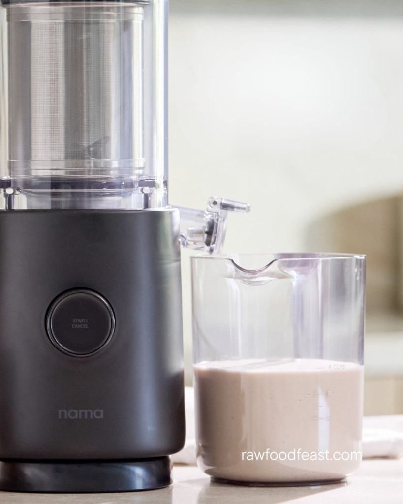 Nama M1 Plant-Based Milk Maker producing creamy cold-pressed nut milk with rich texture in glass container
