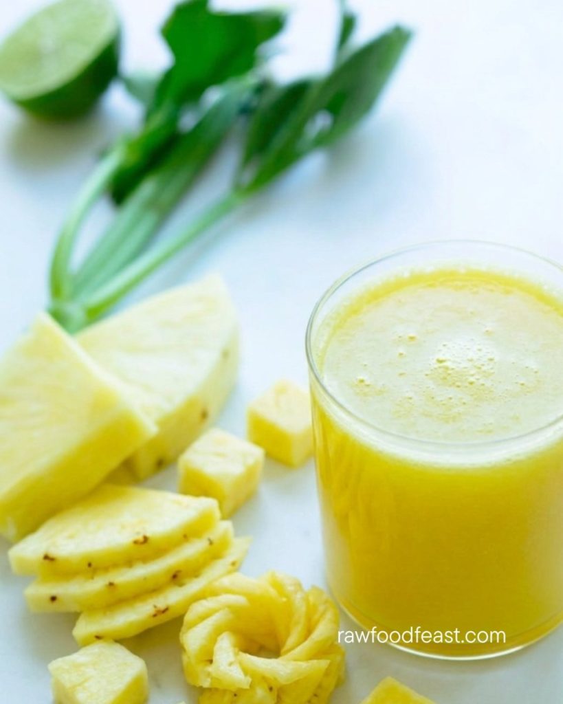 Pineapple juice benefits — a glass of fresh cold-pressed pineapple juice with pineapple slices and chunks on a white surface