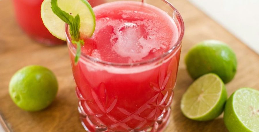A refreshing glass of watermelon juice garnished with lime and mint, highlighting the hydration and watermelon juice benefits for skin.