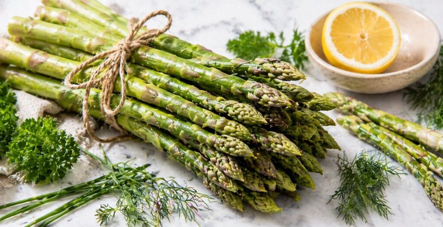 Fresh raw asparagus bunch with lemon and herbs showing the prebiotic asparagus gut health benefit