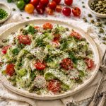 Shaved asparagus salad with creamy oil-free lemon herb dressing on a light marble surface with chives and lemon