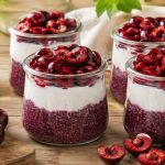 Cherry chia parfait with cherry chia pudding, vanilla coconut whipped cream, and fresh halved cherries