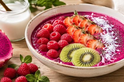 Pink pitaya smoothie bowl with raspberries, strawberries, kiwi, coconut shred, and chia seeds