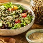Plant foods that restore signs of zinc deficiency — fresh salad with pumpkin seeds, hemp seeds, sprouted lentils, broccoli sprouts, and tahini
